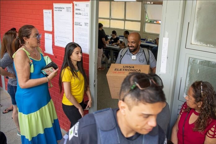 Urna eletrônica sendo recolhida após votação em escola pública do Distrito Federal